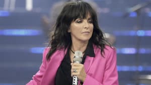 Nena in einem pinken Blazer und mit Mikro in der Hand läuft über die Bühne