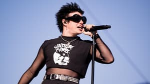 Yungblud mit Mikrofonständer vor blauem Himmel