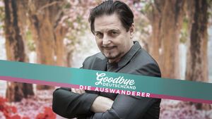 Uwe Herrmann verschränkt die Arme, vor ihm das "Goodbye Deutschland"-Logo