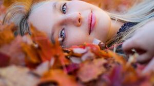 Frau mit perfektem Teint im Herbstlaub