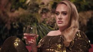 Adele schmollt mit Weinglas in der Hand