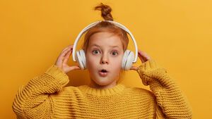 Mädchen hört mit Kopfhörern Tonie-Box