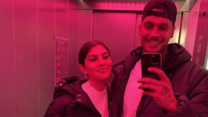 Yeliz Koc und Yasin Mohamed machen ein Spiegelselfie bei rosa Licht