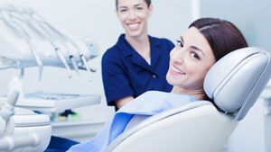 Zahnärztin und Patientin lächeln in die Kamera 