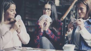 3 Frauen spielen mit karten im Café