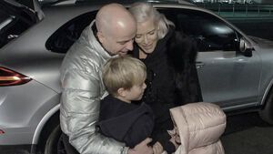 Daniel und Oksana Kolenitchenko umarmen ihre Kinder draußen vor einem Auto