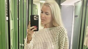 Oksana Kolenitchenko macht ein Spiegel-Selfie mit ernstem Gesichtsausdruck und nahezu ungeschminkt