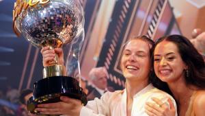 Gabriel Kelly hält den "Let's Dance"-Siegerpokal hoch und Malika Dzumaev umarmt ihn