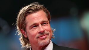 Brad Pitt lächelt und trägt einen Anzug