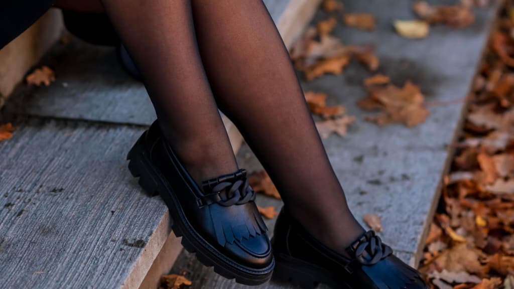 Frau sitzt auf Holzstufen mit Strumpfhose im Herbst