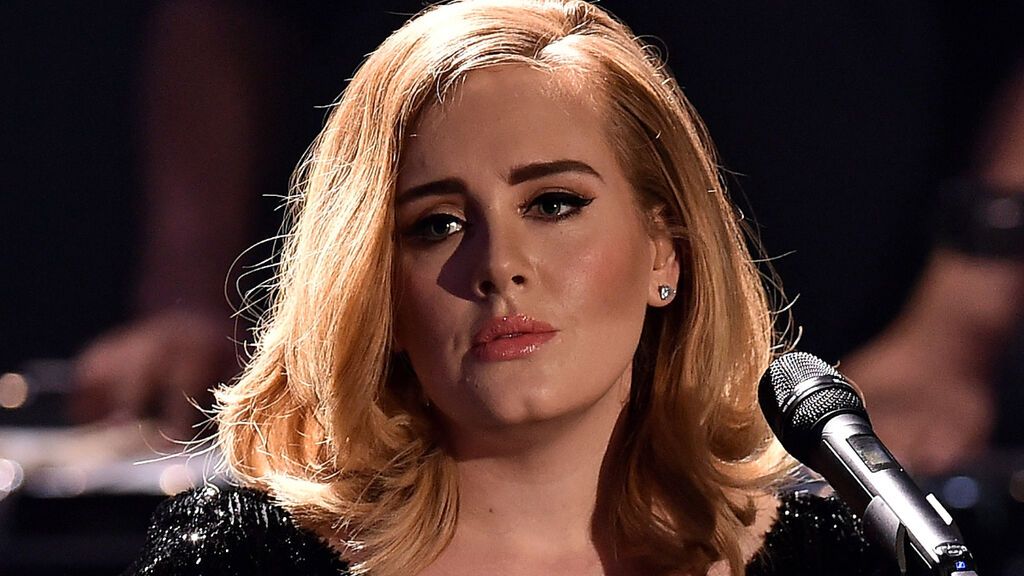 Adele guckt traurig mit Mikrofon.