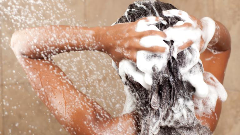 Frau wäscht Haare mit Shampoo