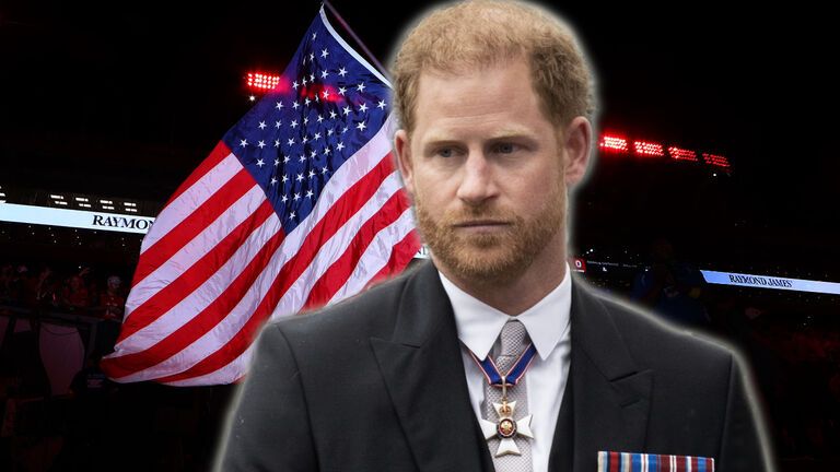 Prinz Harry steht vor einer USA-Flagge, sieht nachdenklich aus