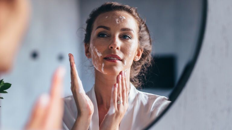 Frau reinigt Gesicht mit Vitamin-C-Reinigungsschaum