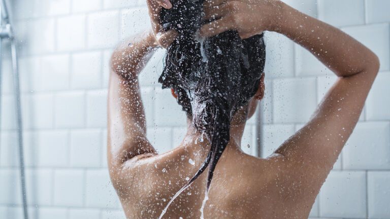 Frau wäscht mit preisgekröntem Shampoo