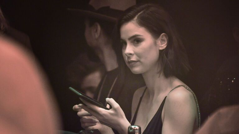 Lena Meyer-Landrut hält ein Handy in der Hand, ihr Gesicht sieht ernst aus