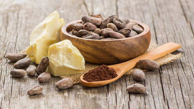 Kakaobutter und Kakaobohnen für die Hautpflege in einer Schale