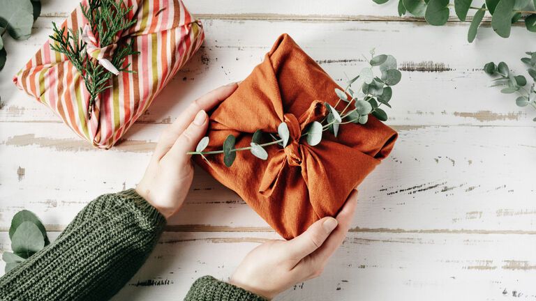 Furoshiki – Hände halten ein nachhaltig verpacktes Geschenk
