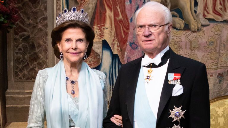 Königin Silvia hakt sich lächelnd bei König Carl Gustaf unter