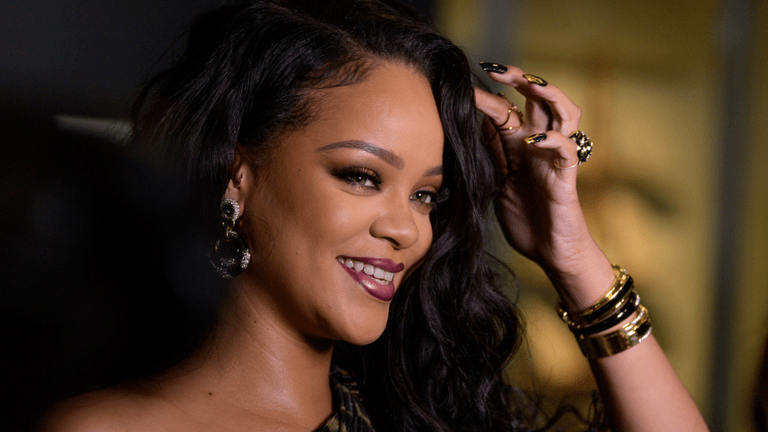 Rihanna lacht und greift sich ins Haar