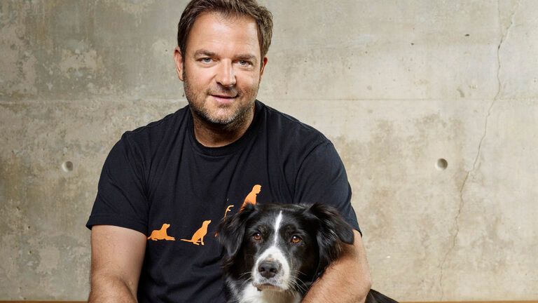Martin Rütter mit Hund im Arm.